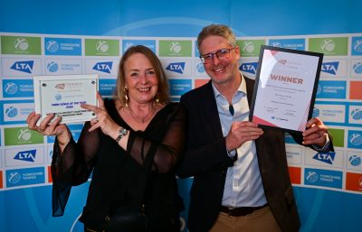 Woman and man holding tennis award