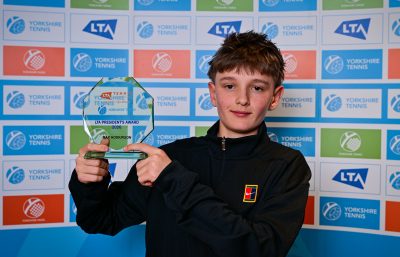 Boy holding tennis trophy